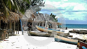 FHand carved fishing boats on the white sand beach in Roatan