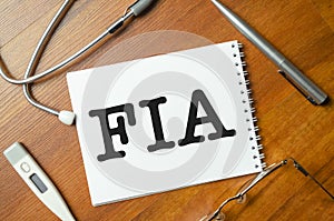 fia abbreviation on with stethoscope on notepad and wooden background