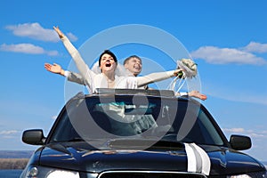 Fiance and bride are glad standing in car