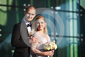 Fiance and fiancee near futuristic building