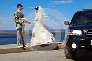 Fiance holds bride for hand outdoor