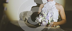 Fiancee in a beautiful white dress holding a beautiful bouquet of wedding flowers made of tender roses and lilies in hand