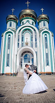 Fiancee and groom, against church