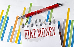 FIAT MONEY text on a notebook with chart and pen business concept