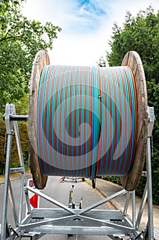 Fiber optic cable on cable reel, colorful cables in red, blue, green on drum, huge spool of cables for high speed internet