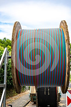 Fiber optic cable on cable reel, colorful cables in red, blue, green on drum, huge spool of cables for high speed internet