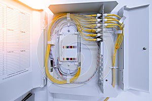 Fiber optic cable connected to enclosure box in a technology data center room.