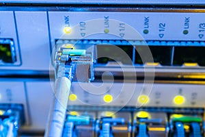 The fiber optic cable is connected to the SFP module of the central server. The concept of high-speed Internet connection.