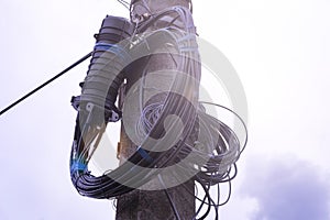 A fiber optic cable harness for communication weighs on a concrete column.