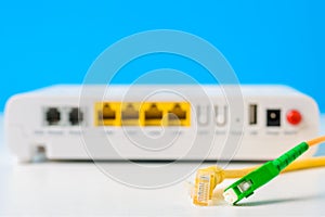 Fiber optical and network cables with internet wireless router on a blue background