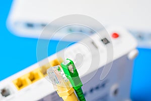 Fiber optical and network cables with internet wireless router on a blue background