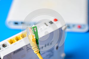 Fiber optical and network cables with internet wireless router on a blue background