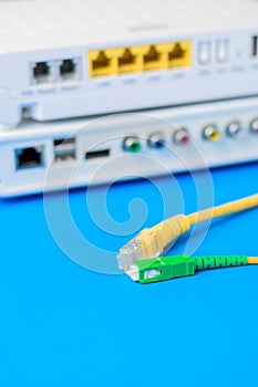 Fiber optical and network cables with internet wireless router on a blue background