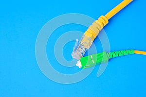 Fiber optical and network rj-45 cables on a blue background