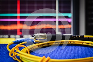 Fibre optic cable with spectrum analiser in the background