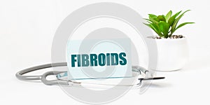 FIBROIDS word on notebook, stethoscope and green plant