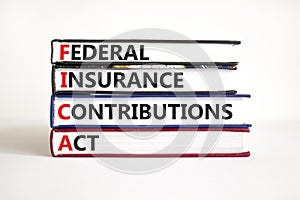 FICA symbol. Concept words FICA federal insurance contributions act on books on beautiful white table white background. Business