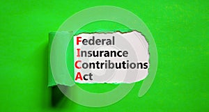 FICA symbol. Concept words FICA federal insurance contributions act on white paper on beautiful green background. Business FICA