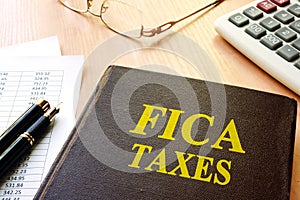FICA Taxes and calculator on a table. photo