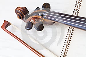 Fiddle bow and scroll on music book