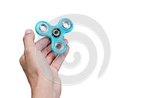 Fidget spinner. Blue hand spinner, fidgeting hand toy rotating on child`s hand. Stress relief. Anti stress and relaxation adhd at