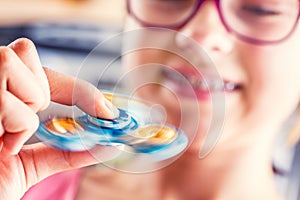 Fidget Spinner. Cute young girl playing with fidget spinner