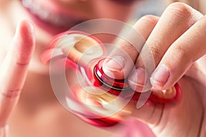 Fidget Spinner. Cute young girl playing with fidget spinner