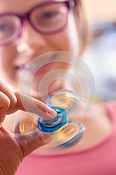 Fidget Spinner. Cute young girl playing with fidget spinner