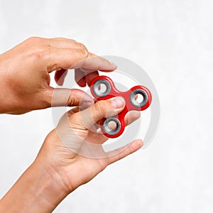 Fidget spinner. Red hand spinner, boys playing with fidgeting hand toy. Stress relief. Anti stress and relaxation adhd