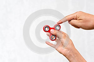 Fidget spinner. Red hand spinner, boys playing with fidgeting hand toy. Stress relief. Anti stress and relaxation adhd attention f
