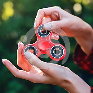 Fidget Spinner. Red sfidget pinner in a girl hand. photo
