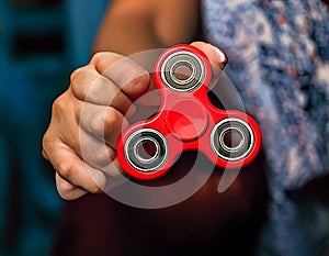 Fidget Spinner. Red sfidget pinner in a girl hand. photo