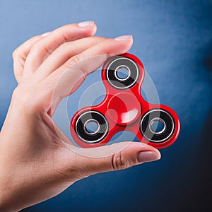 Fidget Spinner. Red sfidget pinner in a girl hand. photo