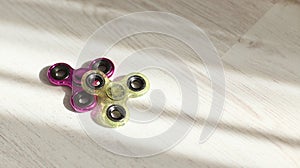 Fidget spinners pink and green stress relieving toys closeup in sunlight