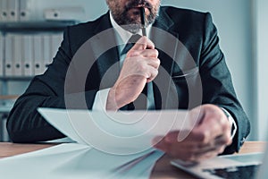 Fiduciary, agent carefully reading business papers in office