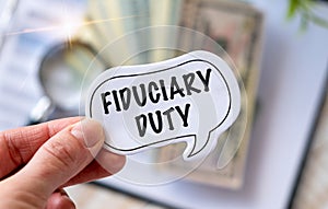 Fiduciary Duty text the a card in Hand. Finance and economics concept. Finance concept