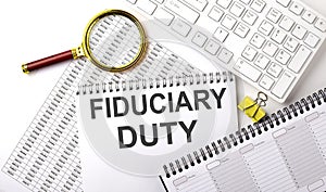 FIDUCIARY DUTY text written on notebook on chart with keyboard and planning