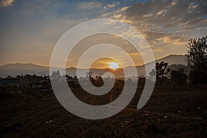 field with beautiful sunset with sun shining with clouds