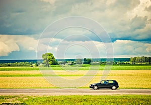 Field and car on a road