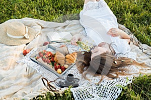 Field in daisies, a bouquet of flowers.Summer picnic by the sea. basket for a picnic with with buns, apples and juice