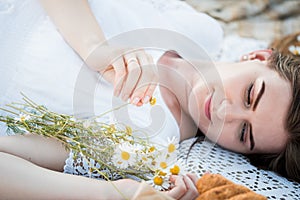 Field in daisies, a bouquet of flowers.Summer picnic by the sea. basket for a picnic with with buns, apples and juice