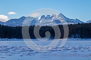 Field of deep crystal snow with scenic view of frozen alpine lake Forstsee, Techelsberg, Carinthia (Kaernten), Austria, Europe