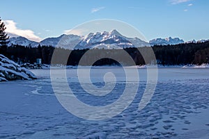 Field of deep crystal snow with scenic view of frozen alpine lake Forstsee, Techelsberg, Carinthia (Kaernten), Austria, Europe