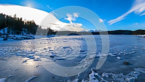 Field of deep crystal snow with scenic view of frozen alpine lake Forstsee, Techelsberg, Carinthia (Kaernten), Austria, Europe