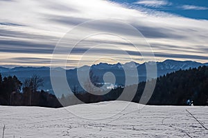 Field of deep crystal snow with scenic view of the snow capped Karawanks mountain range near Techelsberg, Carinthia, Austria