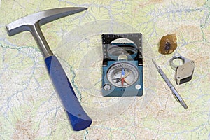 Field equipment geologist laid out on a topographic map. Background