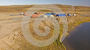 Field geological camp, in the middle of the tundra, with tents and drilling rigs
