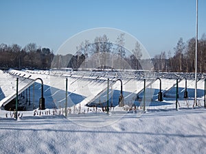 Field of Green Energy Solar Panels Glycol filled providing alternative green energy in winter covered with snow