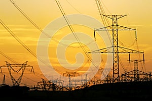 Field of high voltage towers under dramatic sky