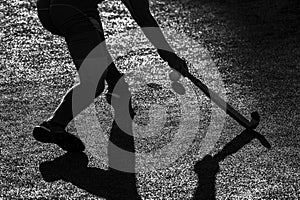 Field Hockey player, ready to pass the ball to a team mate. Black and white color filter